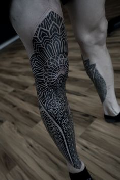 a person with a black and white tattoo on their leg