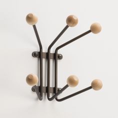 a wall mounted light fixture with six wooden balls on it's arm and four black metal arms