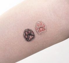 a small paw and heart tattoo on the arm