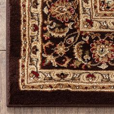 a brown rug with an intricate design on the top and bottom, sitting on a wooden floor