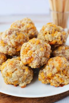 a white plate topped with cheesy meatballs next to a glass of orange juice