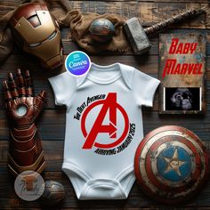 a baby bodysuit with the avengers logo on it next to other items and memorabilia