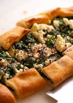 a pizza with spinach and feta cheese on it