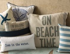 several pillows on a couch with the words i'm building kind of beach time printed on them