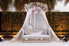 a white couch sitting under a canopy covered in flowers