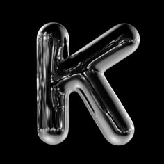 the letter k is made up of shiny chrome foil and it appears to be floating in the air