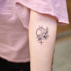 a woman's arm with a cross and flower tattoo on the left inner arm