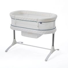 a white baby crib sitting on top of a metal stand in front of a white background