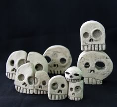 five cement skulls sitting next to each other on a black background