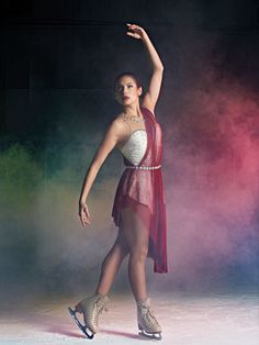 a woman in a red and white dress is doing a ballet move with her arms outstretched