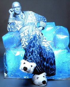 a man sitting on top of an ice chair next to two polar bears and talking on a cell phone