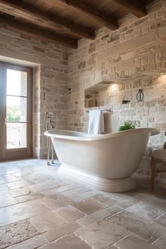 a large white bath tub sitting inside of a bathroom next to a door and window