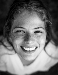 a black and white photo of a woman smiling