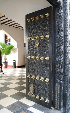 an ornate black door with gold knobs on it