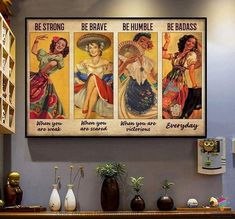 three vintage posters are hanging on the wall above a table with vases and other items