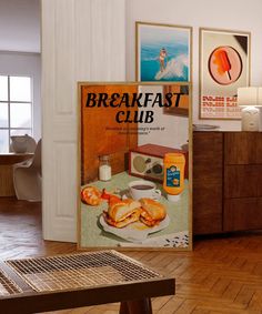 an advertisement for breakfast club is displayed on the wall next to a coffee table and sideboard