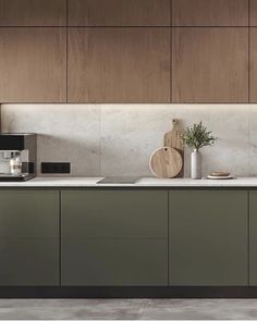 a modern kitchen with green cabinets and white counter tops, along with a potted plant