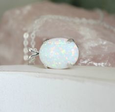 "Beautiful Large white lab-created opal pendant necklace. These gorgeous opals are very similar to natural mined opals. Lab-created opals contain 70-90% silica (from which natural opal is formed) and 10-30% resin. The resin makes the opal harder, stronger, unlike natural opals, which are known to be soft and fragile. Each opal displays a rainbow of color that sparkles with every catch of light. I've handset two different size opals in a solid sterling silver prong settings 16x12mm (5/8\" x 1/2\" White Opal Pendant Jewelry, White Opal Jewelry Gift, White Opal Birthstone Jewelry, White Opal Necklace For Gift, Elegant White Pink Opal Jewelry, White Opal Gemstone Necklace, White Opal Round Pendant Necklace, White Opal Cabochon Necklaces, White Pink Opal Gemstone Jewelry