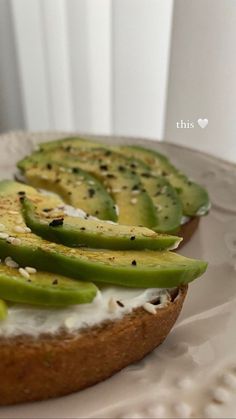 slices of bread with cucumber and cheese on them sitting on a white plate