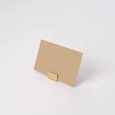 a close up of a piece of paper on a white surface with a gold metal object in the middle