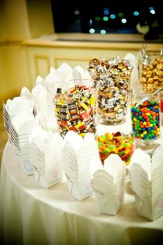 a table topped with lots of candy and candies on top of white paper bags