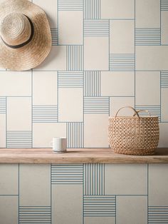 a hat is hanging on the wall next to a basket and cup with a straw in it