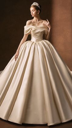 a woman in a ball gown with a tiara standing next to a brown wall