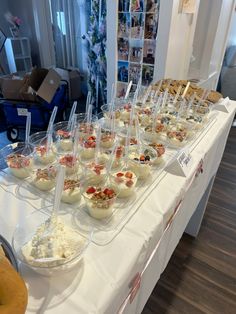 a table topped with lots of food on top of a white tablecloth covered table