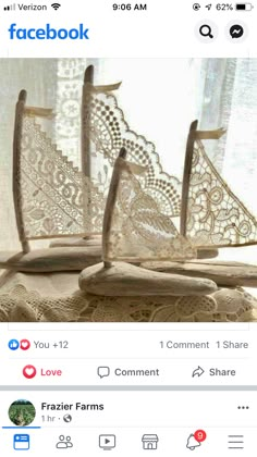 two wooden boats sitting on top of a table next to a window covered in lace