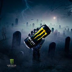 a monster energy drink is held up in the air by a zombie graveyard with tombstones