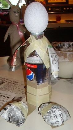 a paper doll made to look like a man with a soda can in his hand