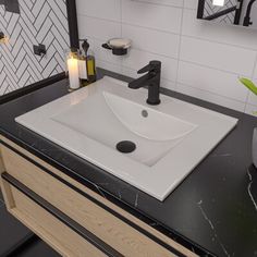 a bathroom sink sitting under a mirror next to a black counter top with candles on it