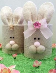 two rabbits made out of toilet paper sitting next to each other on top of grass