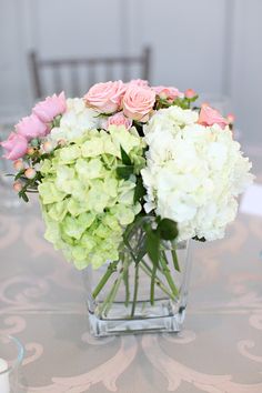 a vase filled with white and pink flowers on top of a table