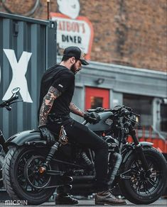 a man with tattoos sitting on a motorcycle