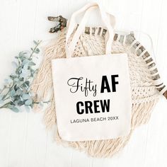 a tote bag with the words fifty af crew on it next to some flowers