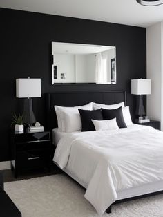 a bedroom with black walls and white bedding