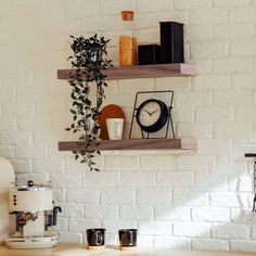 two wooden shelves on the wall with coffee cups and other items in front of them