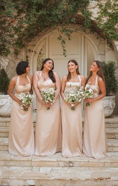 the bridesmaids are all dressed in different styles and colors, posing for a photo