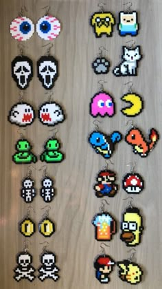 several pixel keychains are displayed on a wooden surface, with different designs and colors