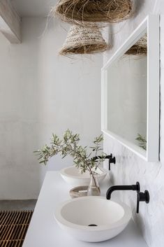 two sinks in a bathroom with hanging baskets above them