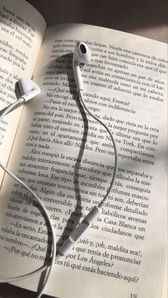 an open book with headphones laying on top of it