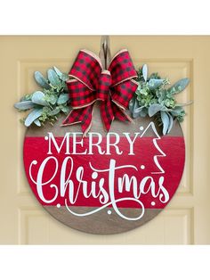 a merry christmas sign hanging on the front door