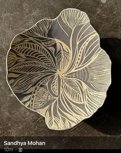 a metal plate sitting on top of a table next to a black and white wall