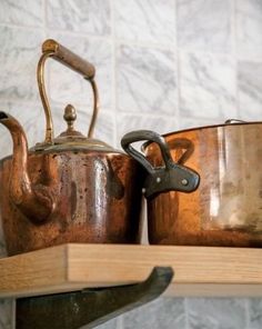 pots and pans are sitting on a shelf