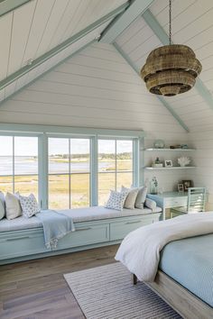 a bedroom with two windows and a bed in the corner, along with a rug on the floor