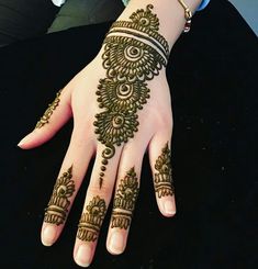 a woman's hand with henna tattoos on it