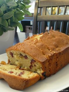 a loaf of bread sitting on top of a white plate next to a potted plant