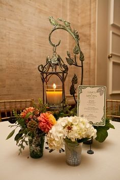 a table topped with flowers and a lit candle