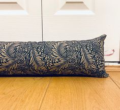 a decorative pillow sitting on the floor in front of a door with two white doors